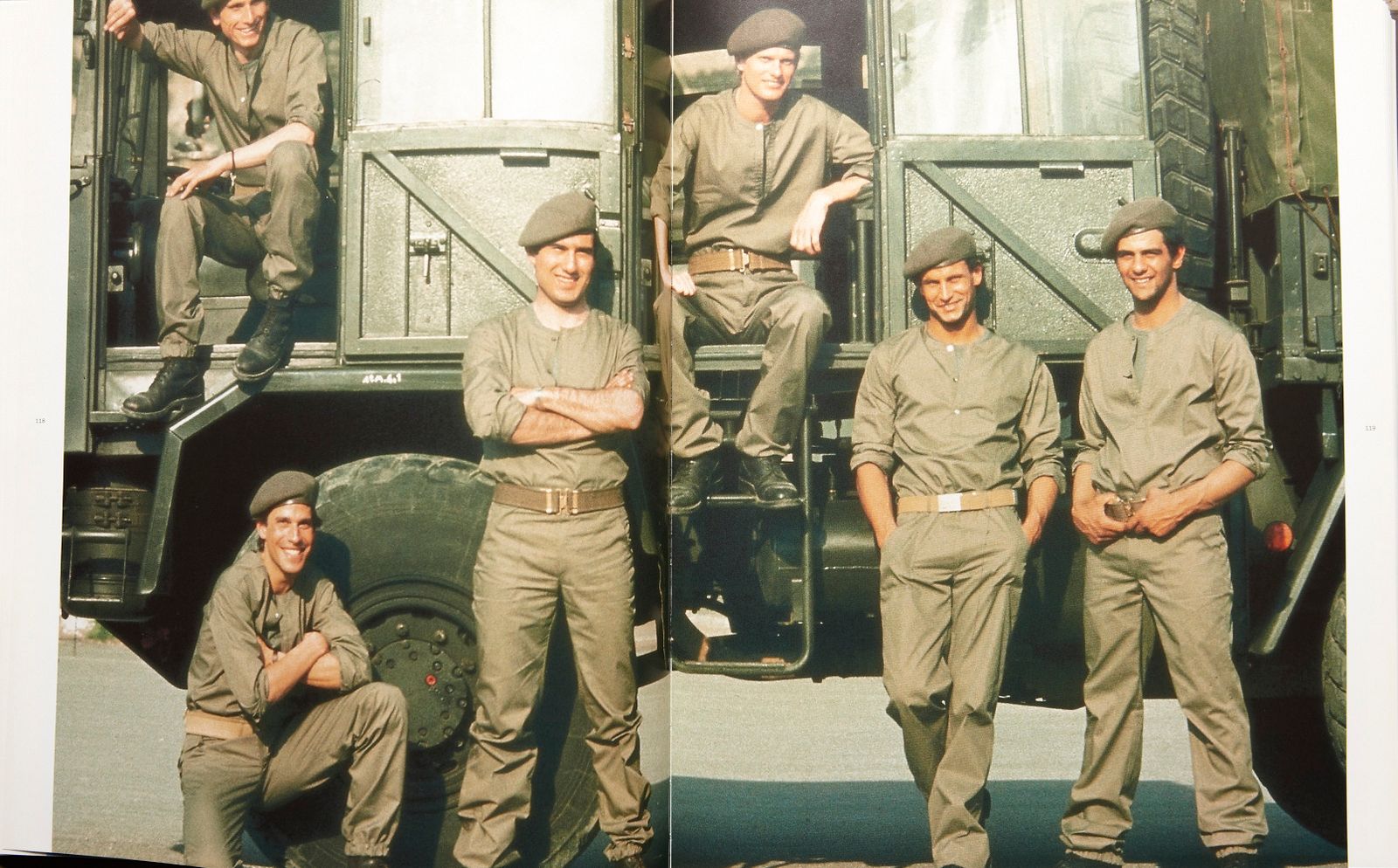 a group of men standing next to each other in front of a truck