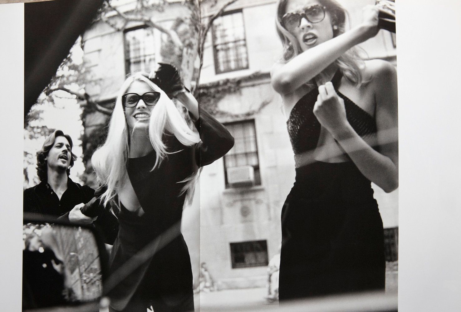 a black and white photo of two women in front of a building