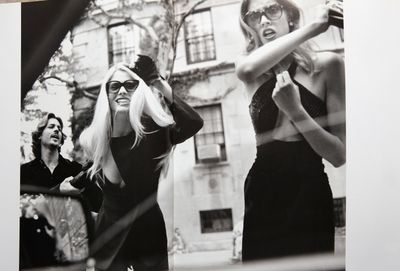 a black and white photo of two women in front of a building