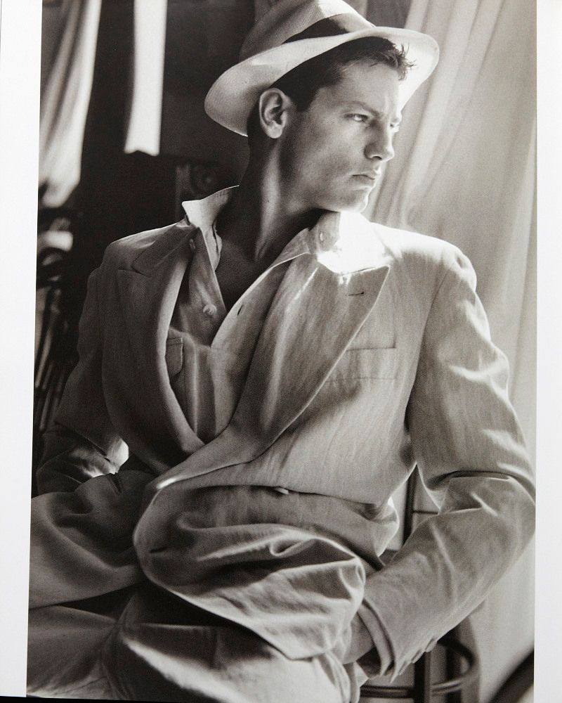 a black and white photo of a man in a suit and hat