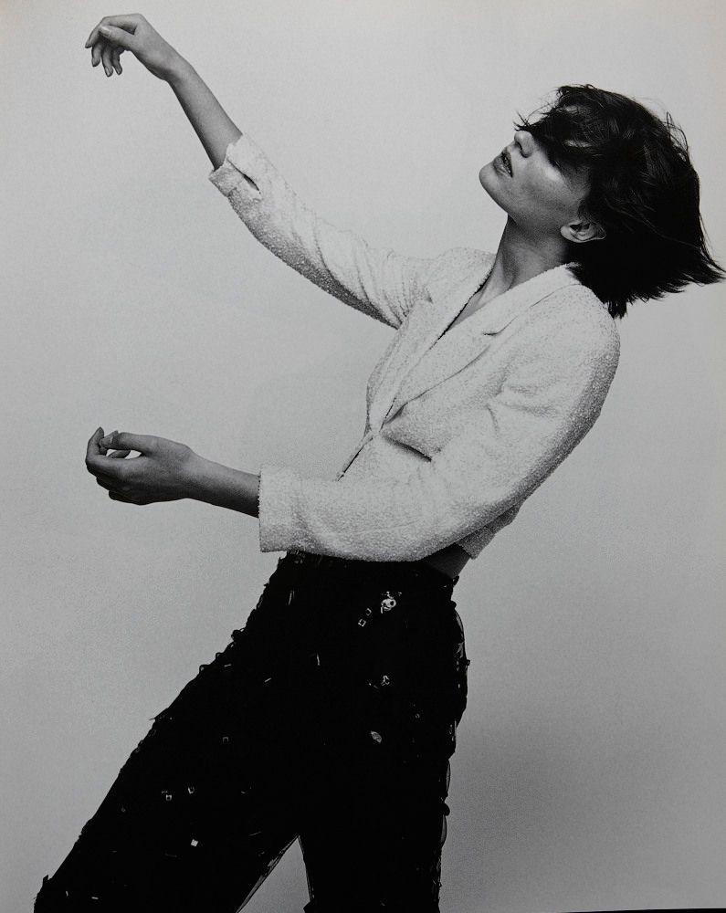 a black and white photo of a woman holding a tennis racquet