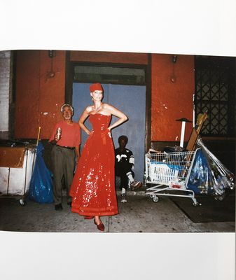 a woman in a red dress standing in front of a store