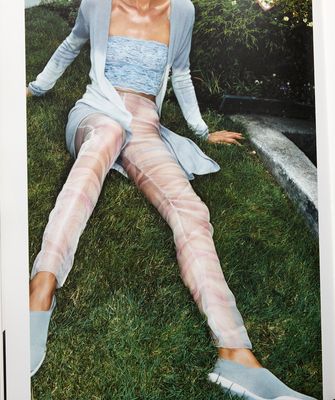 a woman sitting on the grass wearing sheer stockings