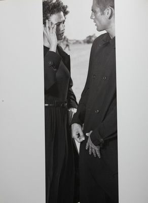 a black and white photo of two people talking