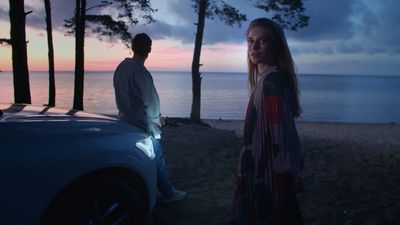 a man and a woman standing next to a car