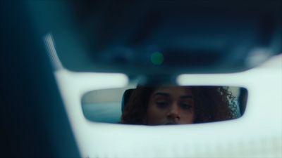 a woman's reflection in a rear view mirror