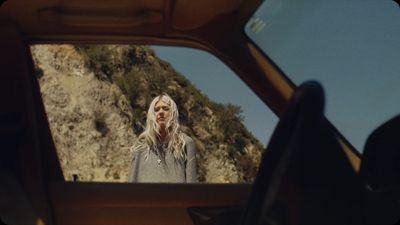 a woman standing in front of a mirror in a car