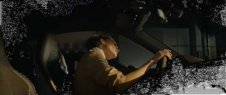 a person sitting in a car with a steering wheel