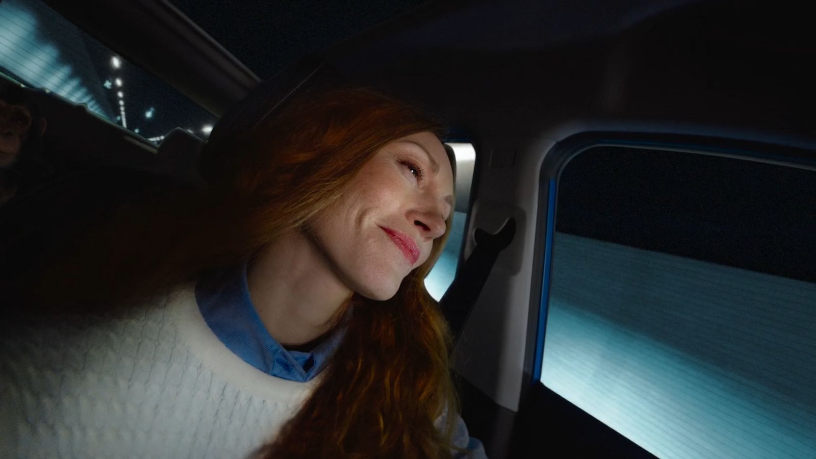 a woman sitting in a car with her eyes closed