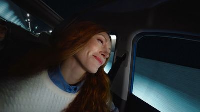 a woman sitting in a car with her eyes closed