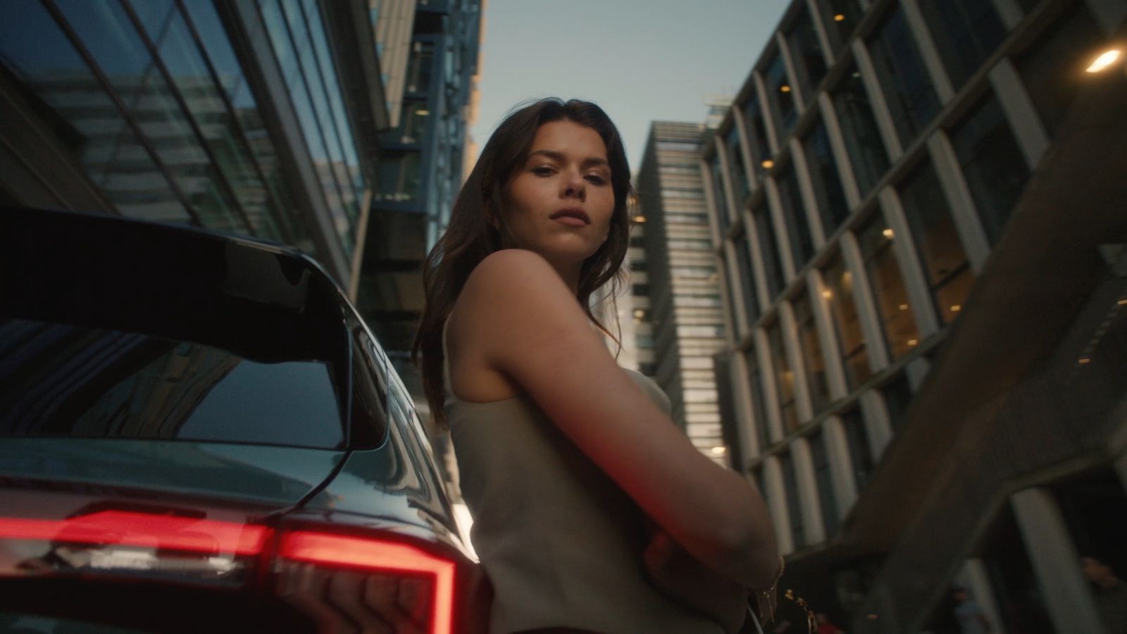 a woman standing next to a car in a city