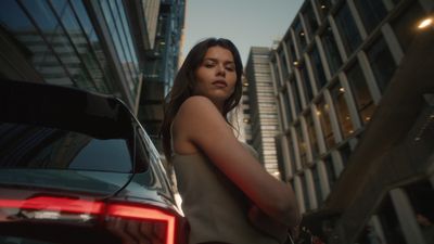 a woman standing next to a car in a city