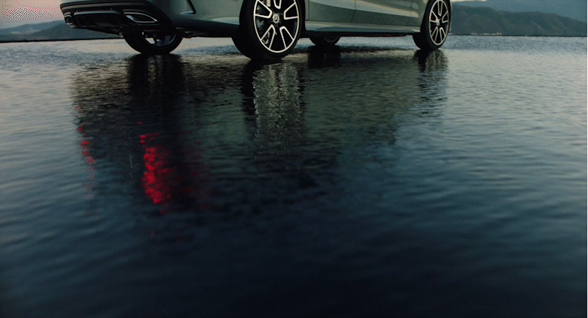 a silver car is parked on the water