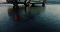 a silver car is parked on the water