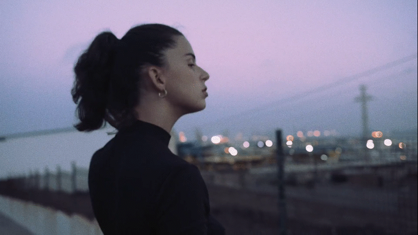 a woman standing in front of a fence at night