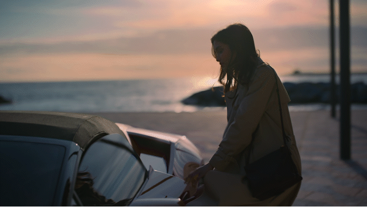 a woman standing next to a parked car