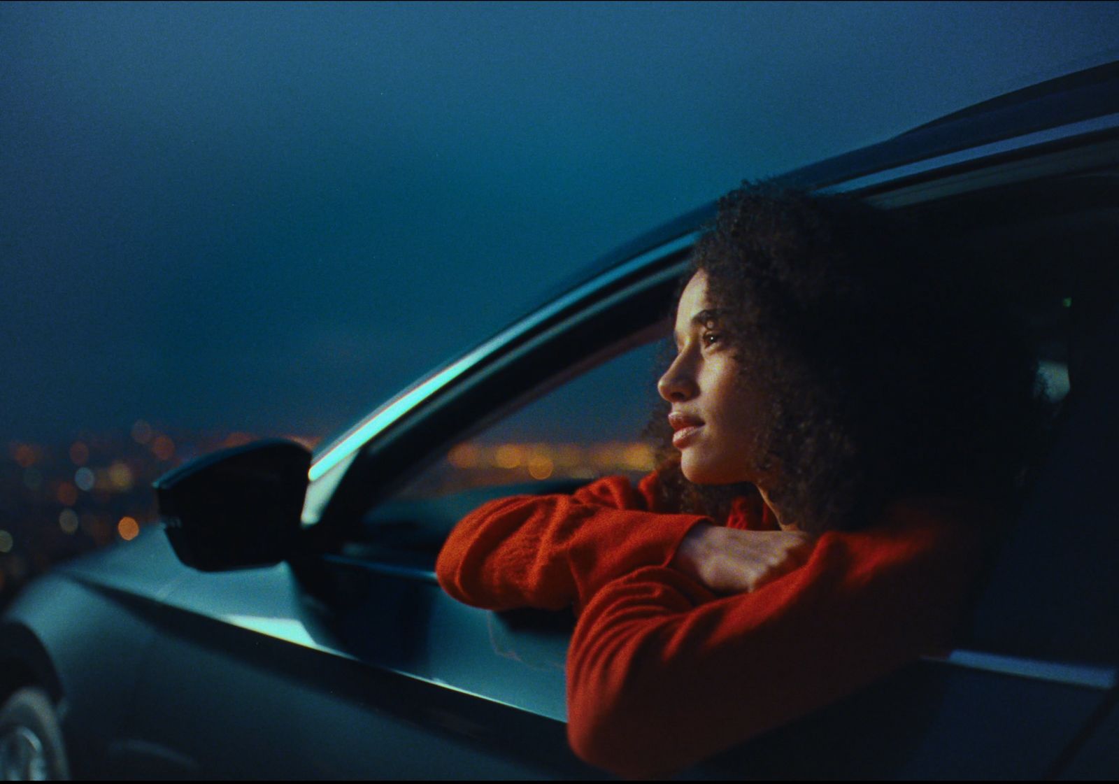 a woman leaning out of a car window at night