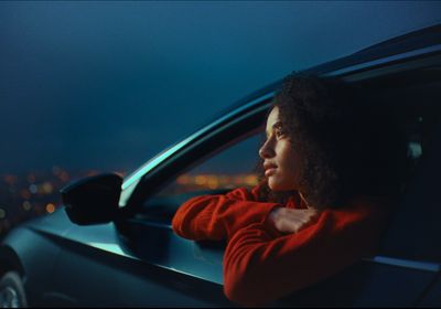 a woman leaning out of a car window at night