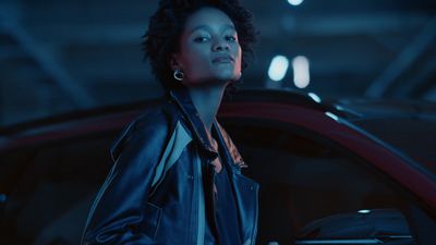 a woman standing next to a car in a garage
