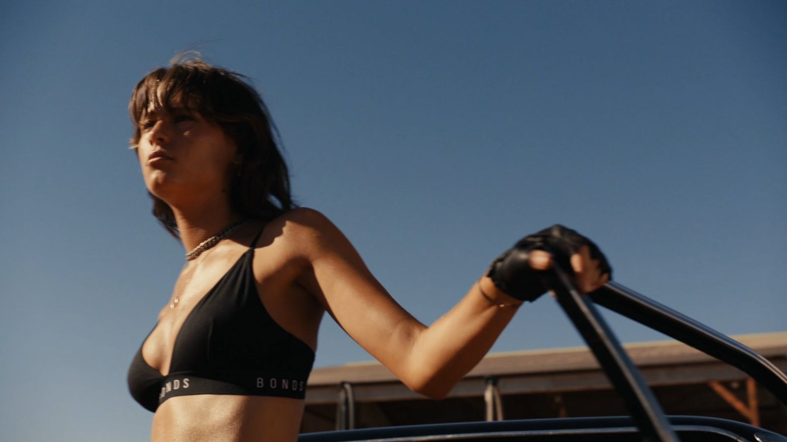 a woman in a bikini standing next to a car