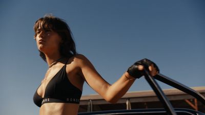 a woman in a bikini standing next to a car