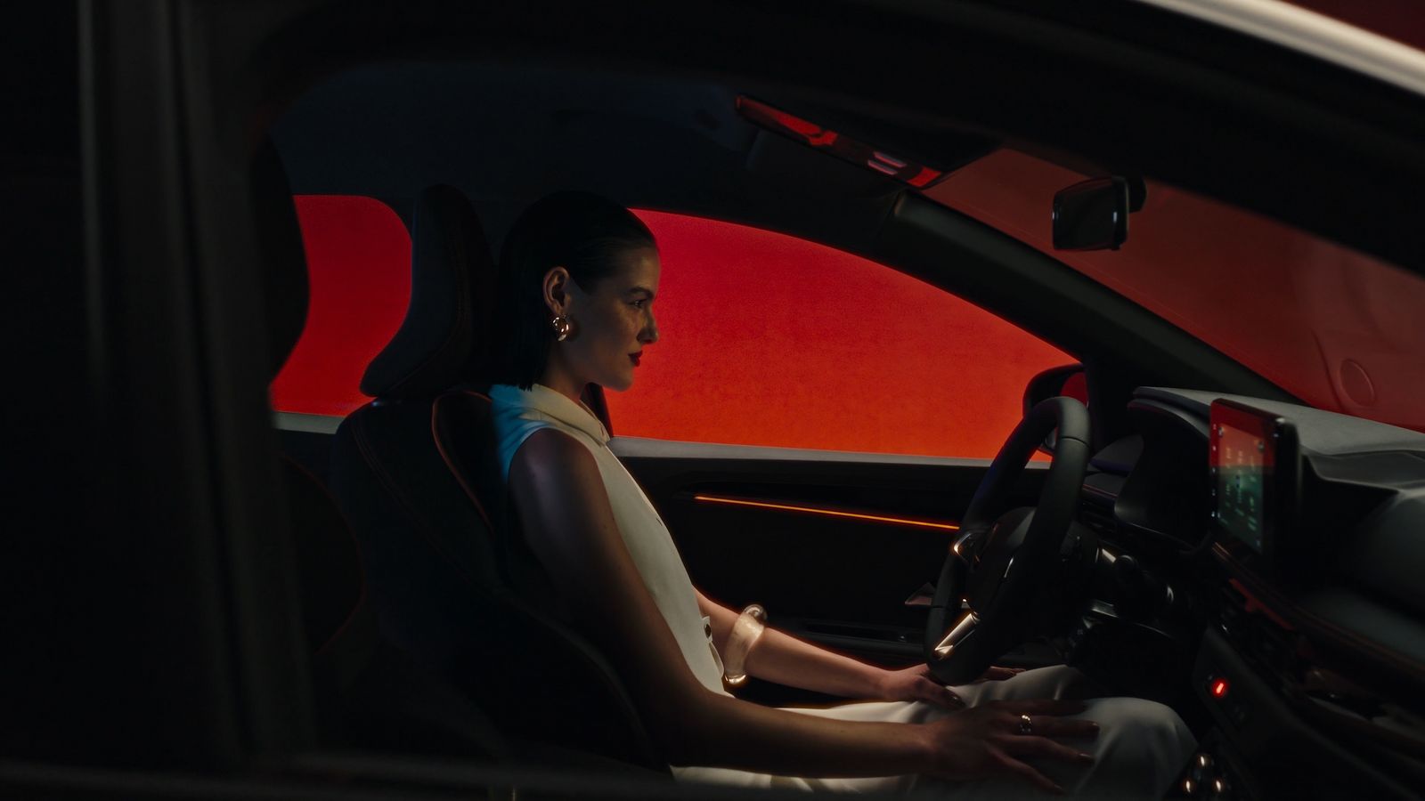 a woman driving a car in the dark