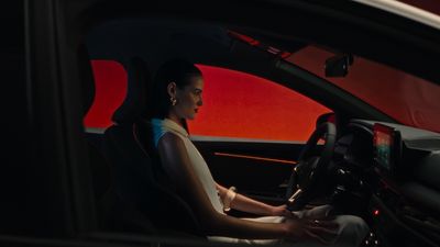 a woman driving a car in the dark