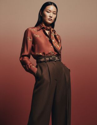 a woman in a red shirt and brown pants