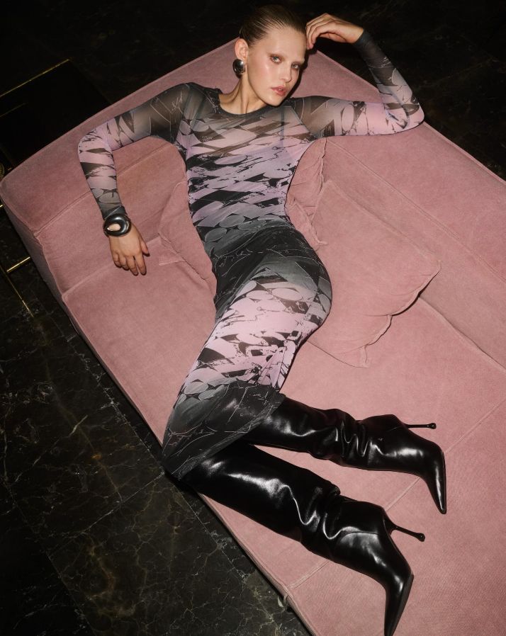 a woman laying on top of a pink couch