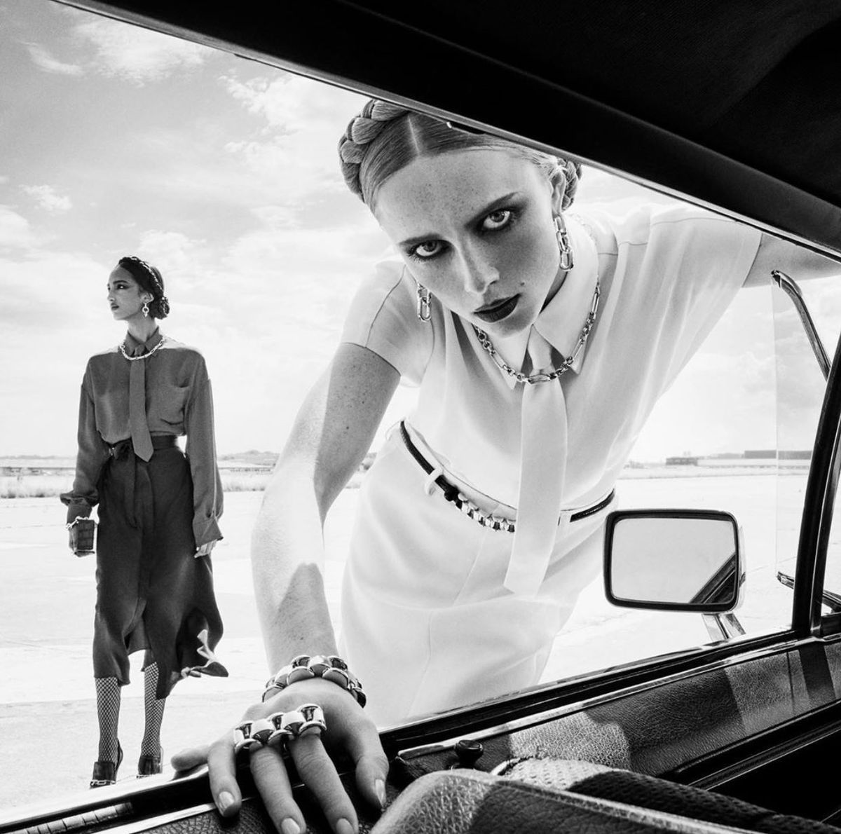 a black and white photo of two women in a car