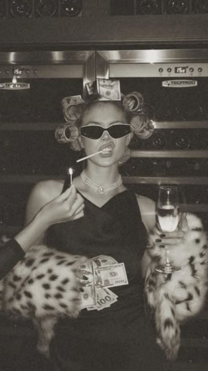 a woman smoking a cigarette and holding a glass of wine