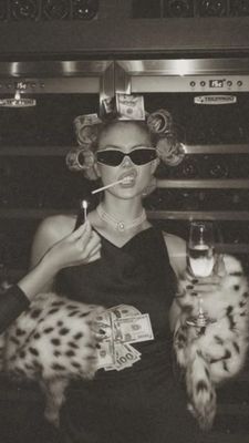 a woman smoking a cigarette and holding a glass of wine