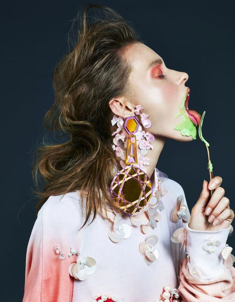 a woman with long hair blowing out a flower