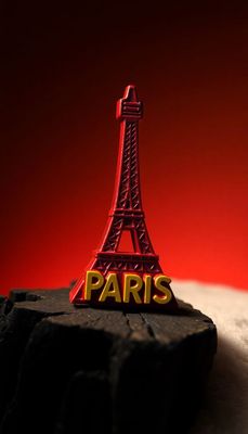 a red eiffel tower on top of a rock