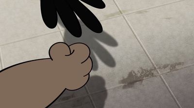 a hand reaching for a glove on a tiled floor