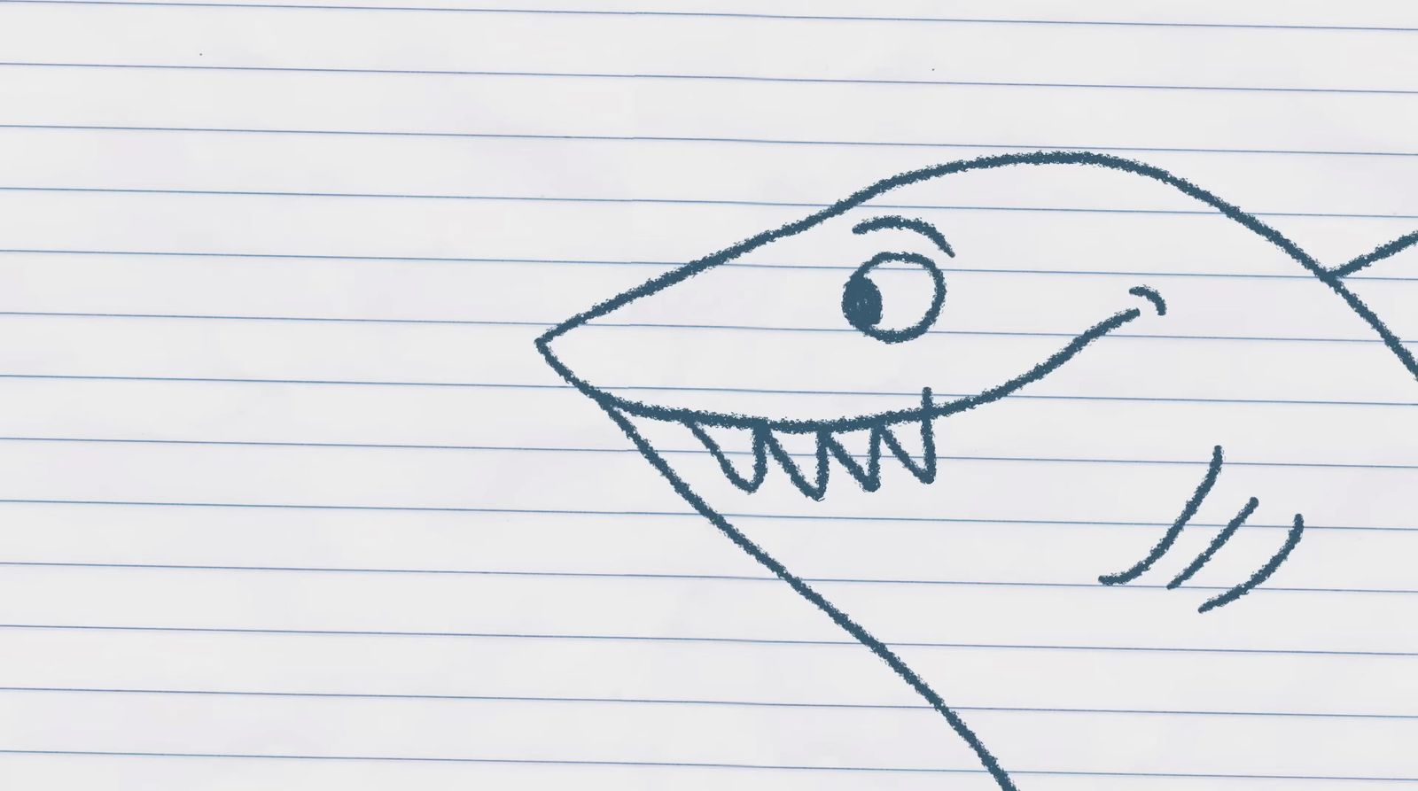 a drawing of a smiling shark on lined paper