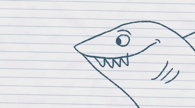 a drawing of a smiling shark on lined paper