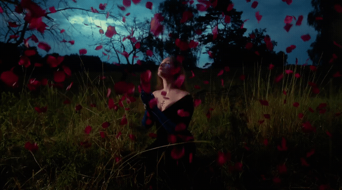 a woman standing in a field of flowers
