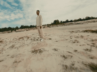 a man standing on top of a sandy beach