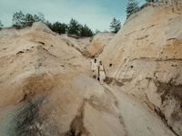 a couple of people standing on top of a mountain