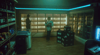 two people standing in a room with shelves of liquor