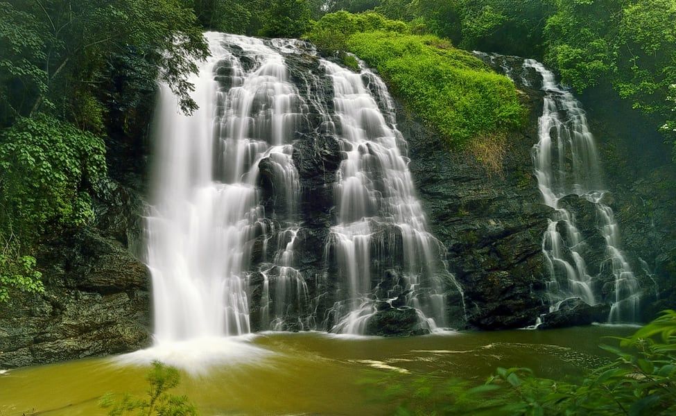 a large waterfall in the middle of a forest