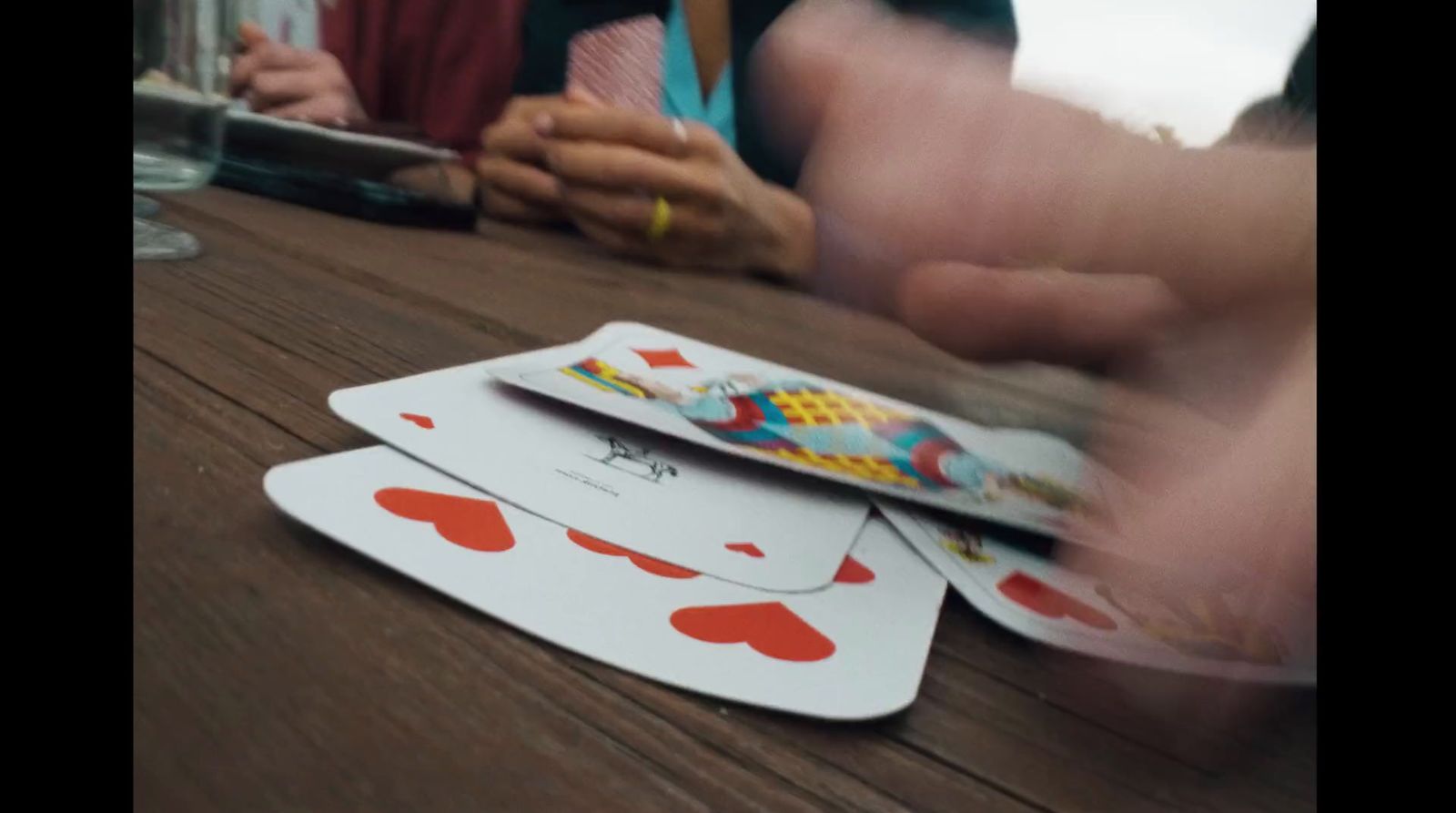 a table topped with playing cards on top of a wooden table