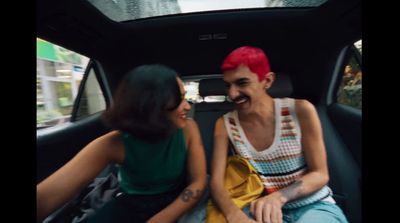 a man and a woman sitting in the back of a car