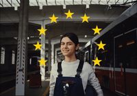 a woman with a backpack standing in front of a train