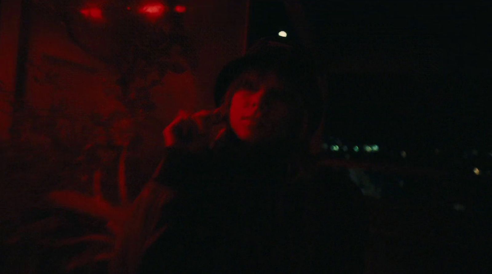 a person standing in a dark room with a red light