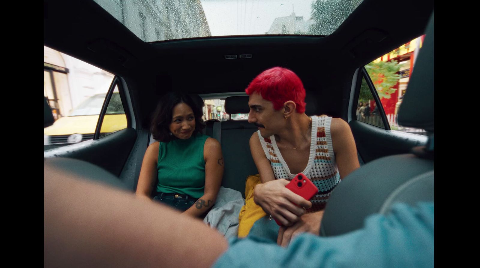 a man and a woman sitting in the back of a car