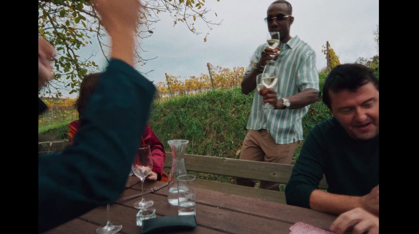 a man sitting at a table with a glass of wine