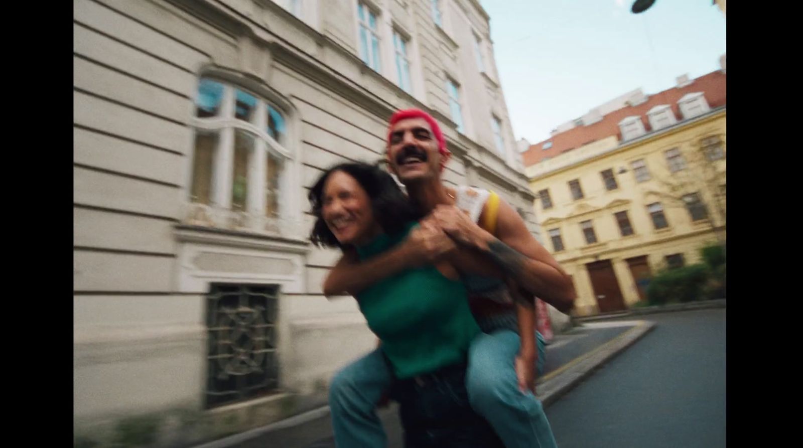 a man riding on the back of a woman on a skateboard