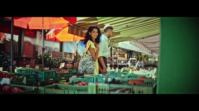 a man and a woman walking through a market